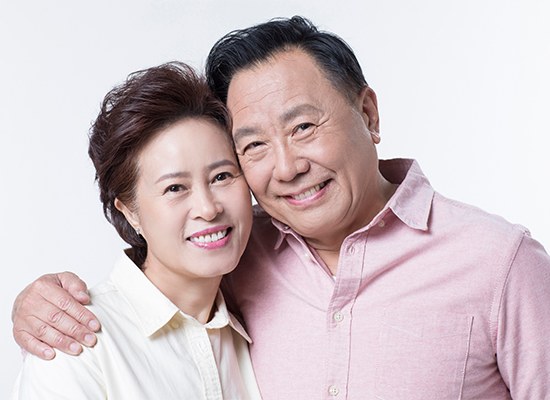 웃으며 함께 서 있는 노년 부부