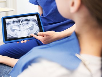 태블릿으로 X-ray 사진을 보여주며 상담하는 모습